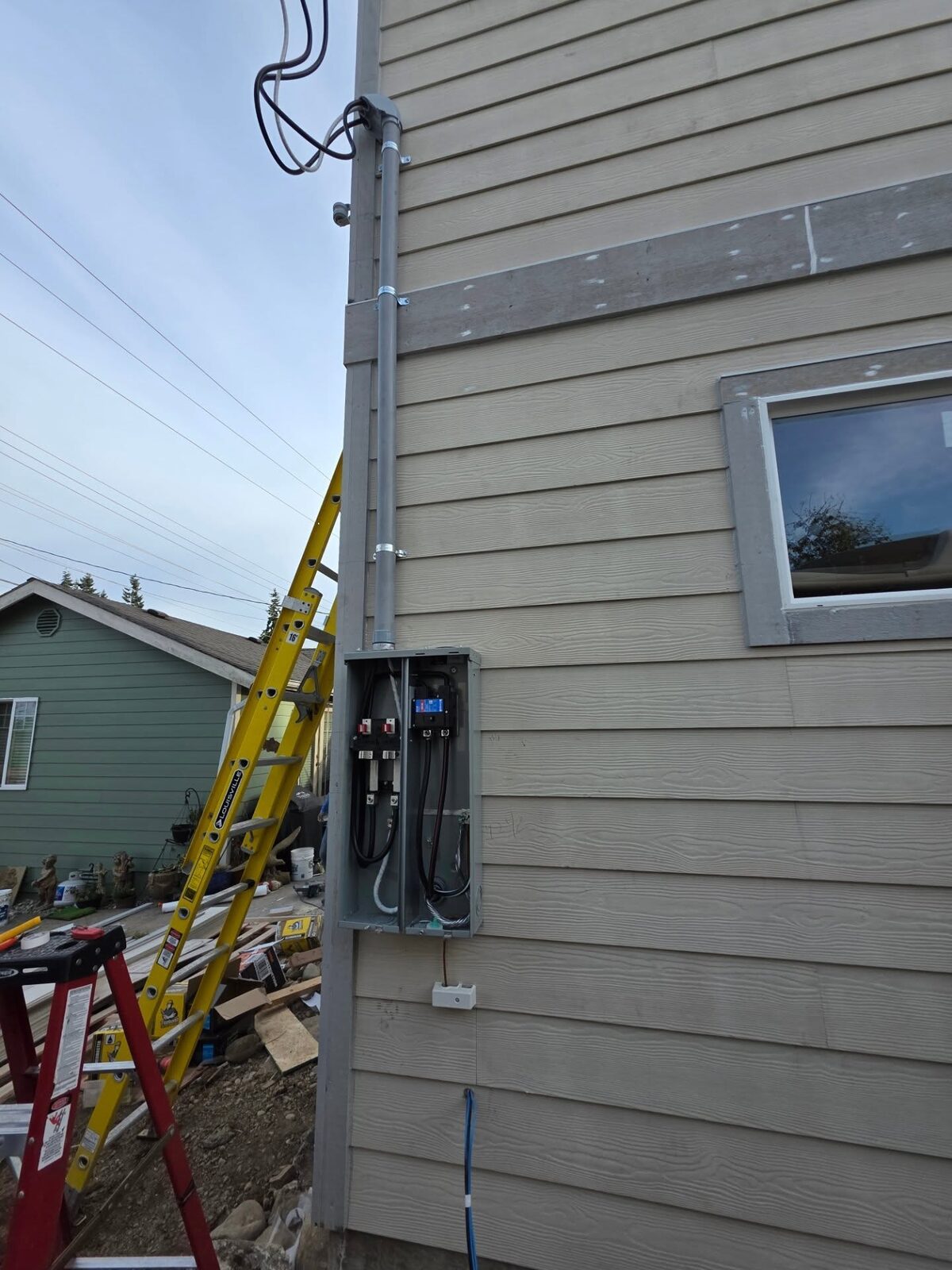 Exterior conduit run into an open 200-amp meter panel with breakers visible